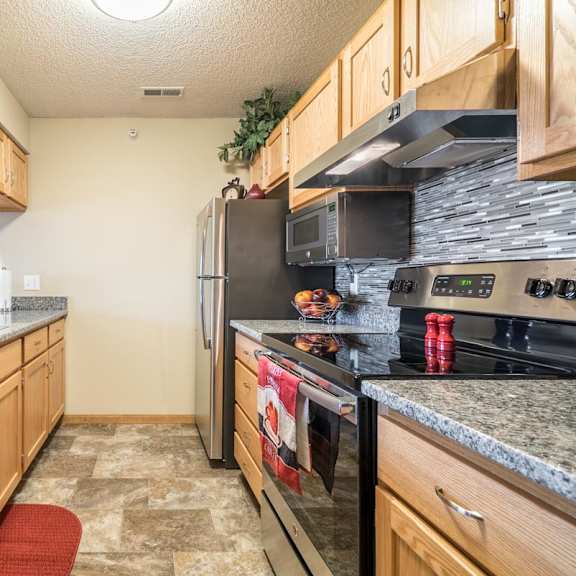 Thumbnail 7 of 16 A kitchen with granite countertops and stainless steel appliances.