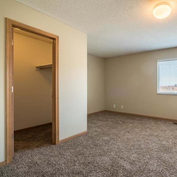 Thumbnail 9 of 16 A room with a carpeted floor and a window with blinds.