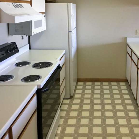 Thumbnail 17 of 24 a kitchen with white appliances and white and brown cabients