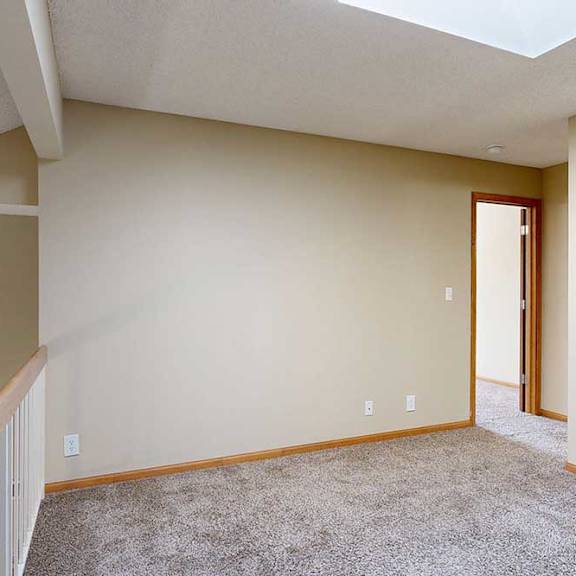 Thumbnail 23 of 27 Upper loft area with carpet flooring, white railing, skylight, and view down to the living room below.