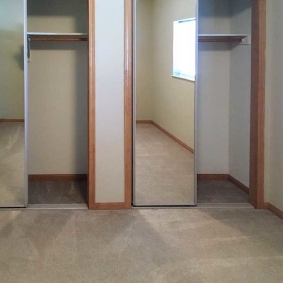 Thumbnail 7 of 11 a bedroom with two closets, both with sliding mirror doors