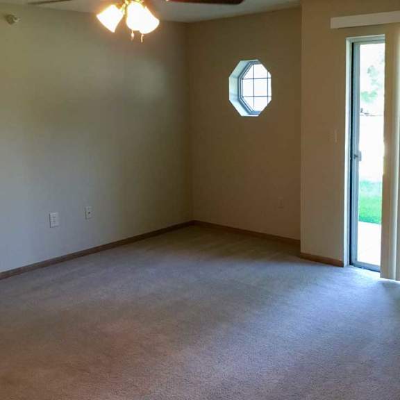 Thumbnail 6 of 11 a living room with a carpeted floor and a ceiling fan