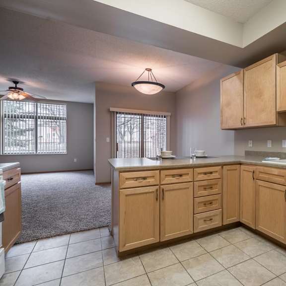 Thumbnail 19 of 21 A kitchen with wooden cabinets and a white dishwasher.