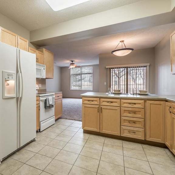 Thumbnail 18 of 21 A kitchen with a refrigerator, oven, and cabinets.