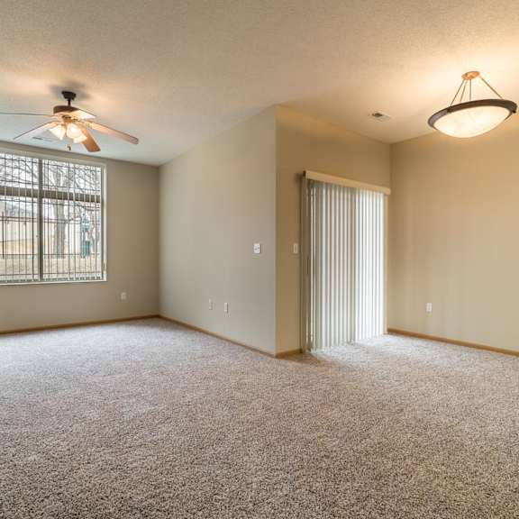 Thumbnail 20 of 21 A room with a ceiling fan and carpeted floor.