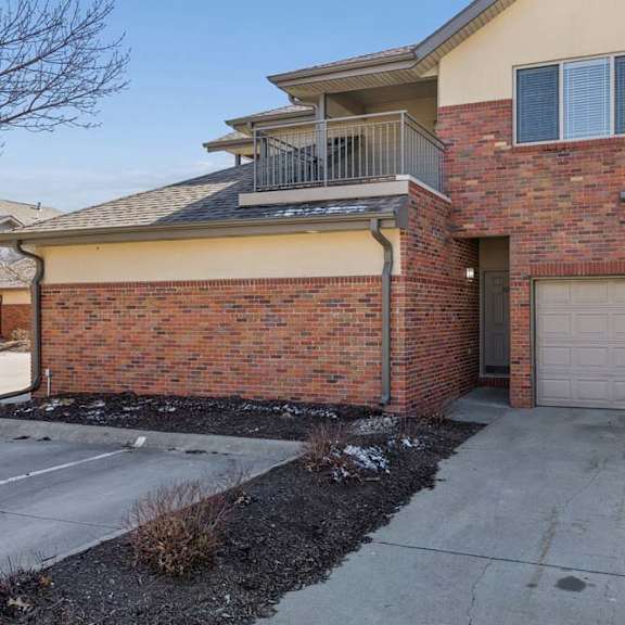 Thumbnail 27 of 38 Front exterior of multi-level brick townhome with private garage entrance.
