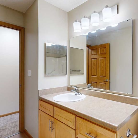 Thumbnail 22 of 26 a bathroom with a vanity sink and a mirror with overhead lighting