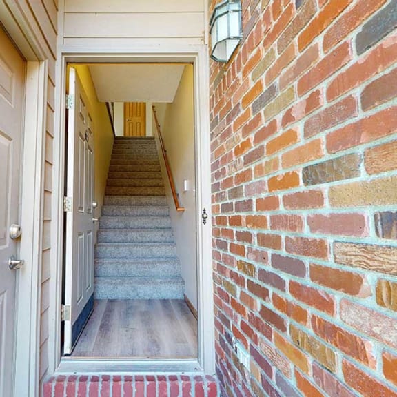 Thumbnail 3 of 26 a front door leading into an apartment staircase adjacent from a door to an attached garage