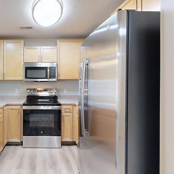 Thumbnail 14 of 26 a kitchen with stainless steel appliances and wooden cabinets
