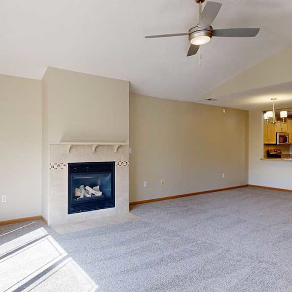 Thumbnail 7 of 26 a living room with a ceiling fan and a fireplace