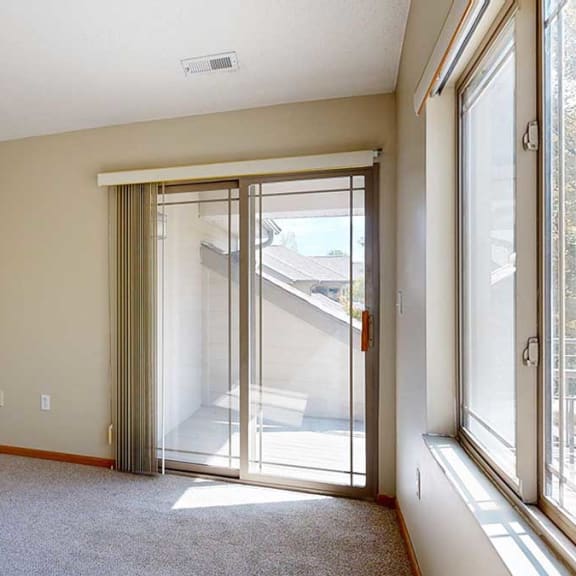 Thumbnail 9 of 26 a living room with a sliding glass door leading to a balcony