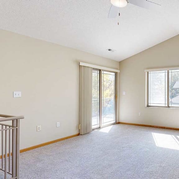 Thumbnail 6 of 26 a living room with a large window, a fireplace, and a door to a balcony