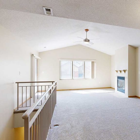 Thumbnail 5 of 26 a living room next to a staircase that has a ceiling fan and fireplace