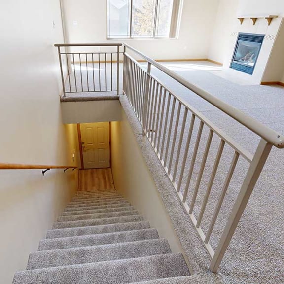 Thumbnail 4 of 26 a carpeted staircase with a metal railing at the top that leads to a door