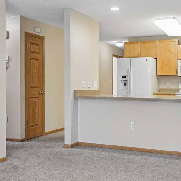 Thumbnail 3 of 17 Kitchen featuring a wide peninsula counter, white refrigerator, and open layout.