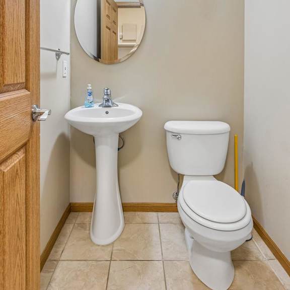 Thumbnail 13 of 29 Apartment powder room with pedestal sink, framed mirror, neutral walls, and convenient main-level location.