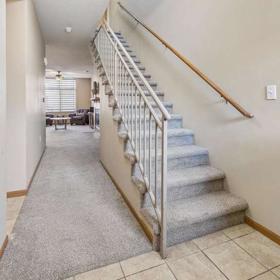 Thumbnail 3 of 29 Apartment entry hallway with carpeted staircase, neutral finishes, and open layout leading to the main living area.