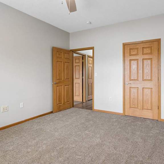Thumbnail 13 of 18 Bedroom with carpeted floor, closet access, and hallway door.