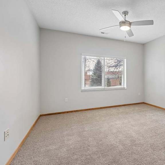 Thumbnail 14 of 18 Carpeted bedroom with ceiling fan and window.