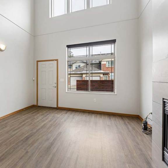 Thumbnail 4 of 18 Bright living room featuring vaulted ceilings and plank flooring.