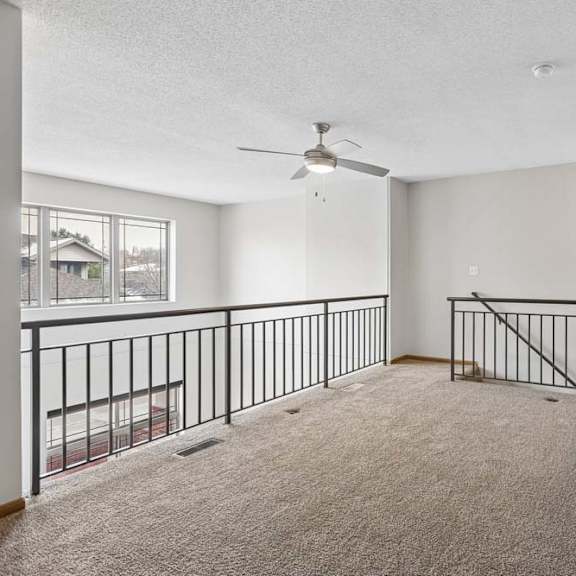 Thumbnail 9 of 18 Spacious loft area overlooking the lower level with carpet and railing.