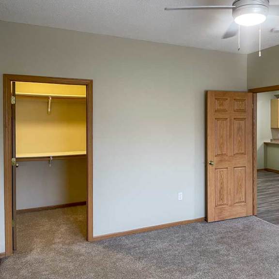 Thumbnail 14 of 18 a bedroom with a ceiling fan and a walk-in closet