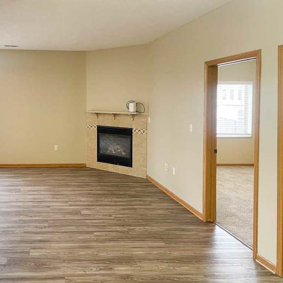 Thumbnail 13 of 18 a living room with a fireplace and luxury vinyl hardwood flooring