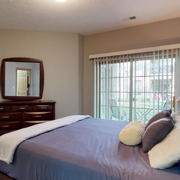 Thumbnail 15 of 19 a bedroom with a bed and a dresser with a mirror