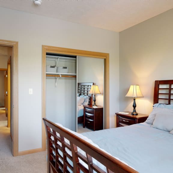 Thumbnail 11 of 19 a bedroom with a bed and a mirrored closet door