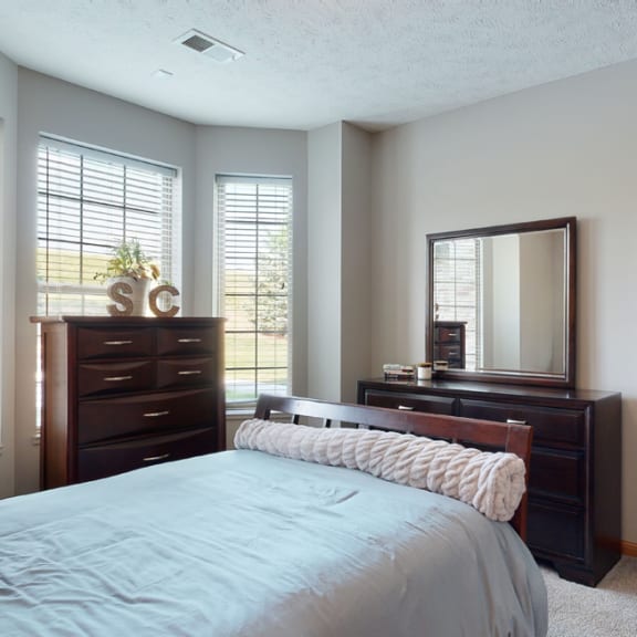 Thumbnail 10 of 19 a bedroom with a bed and a dresser and a mirror