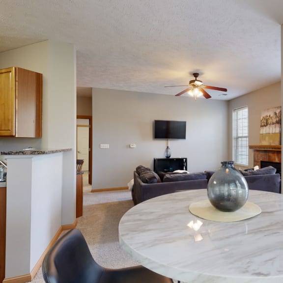 Thumbnail 8 of 19 an open living room and dining room with a marble table and a ceiling fan