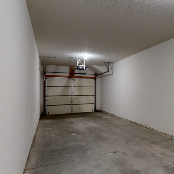Thumbnail 19 of 19 the inside of a garage with a white wall and a garage door