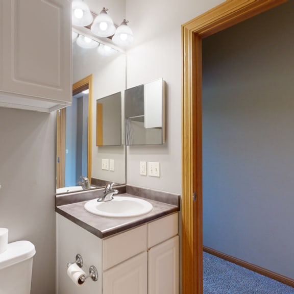 Thumbnail 13 of 19 a bathroom with a sink toilet and mirror with cabinet storage