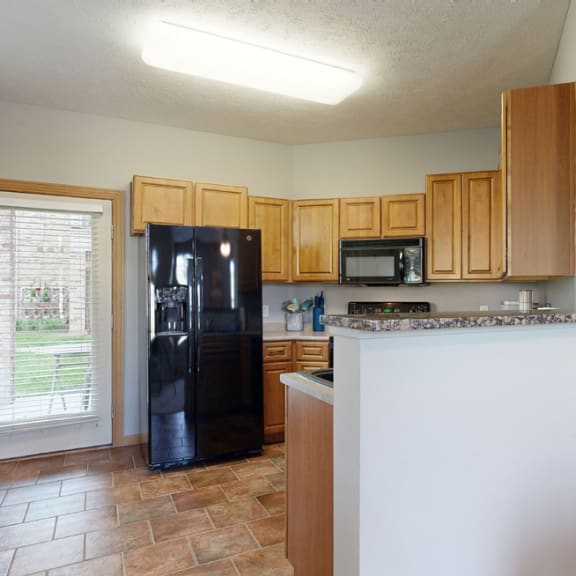 Thumbnail 6 of 19 a kitchen with an island and a black refrigerator