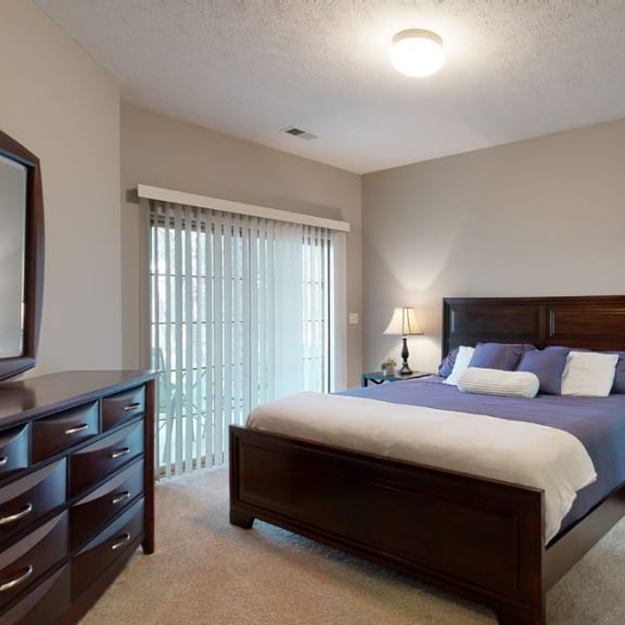 Thumbnail 14 of 19 a bedroom with a bed and a dresser with large mirror on top