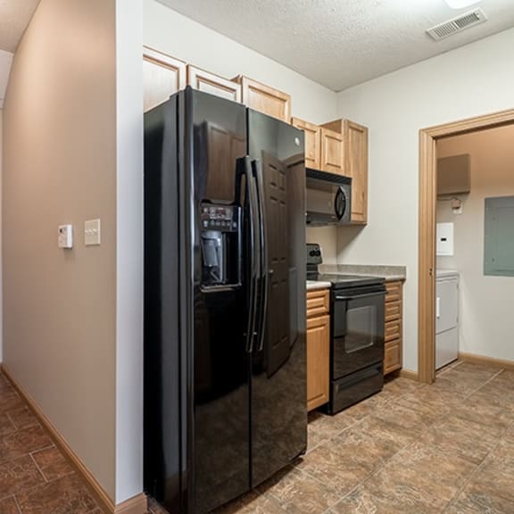 Thumbnail 2 of 9 a kitchen with a refrigerator and a stove and a microwave