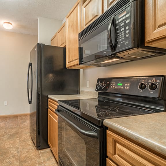 Thumbnail 3 of 9 Kitchen with flat-top stove at Stone Creek Villas Apartments in Omaha Nebraska