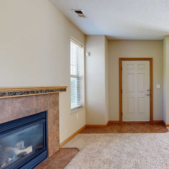 Thumbnail 2 of 28 a living room with a fireplace and a front door