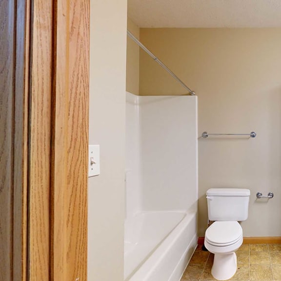 Thumbnail 24 of 28 a bathroom with a toilet, a sink, a shower tub, and tall white storage cabinets
