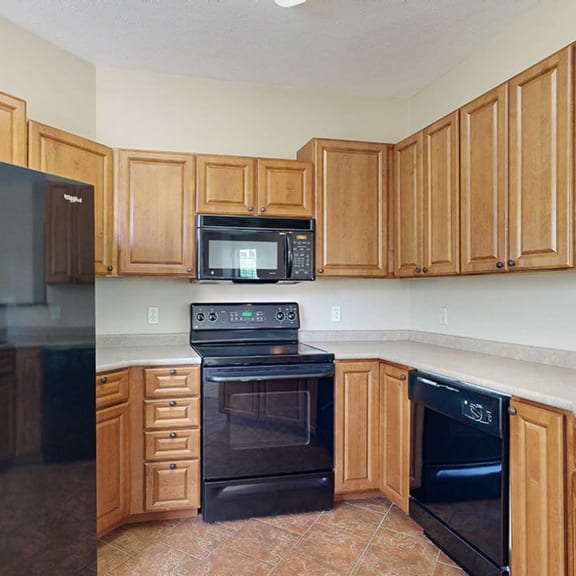 Thumbnail 9 of 28 a kitchen with black appliances and wooden cabinets