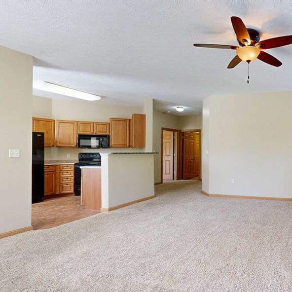 Thumbnail 14 of 28 a living room with a ceiling fan next to a kitchen