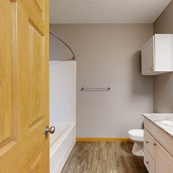 Thumbnail 18 of 24 a bathroom with tub and shower, a toilet, and double sink with granite countertops and a mirror