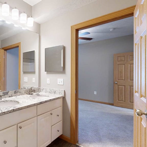 Thumbnail 19 of 24 a bathroom with a vanity sink with granite counter top and a mirror with overhead lighting