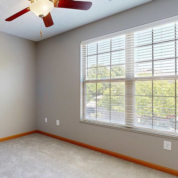 Thumbnail 23 of 24 a bedroom with a large window and a ceiling fan