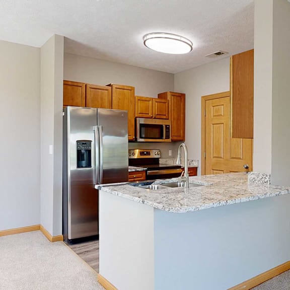 Thumbnail 5 of 24 a kitchen with a granite counter top and a stainless steel refrigerator