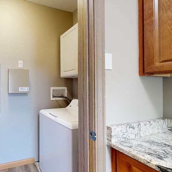 Thumbnail 8 of 24 a laundry room with a washer and dryer and overhead storage