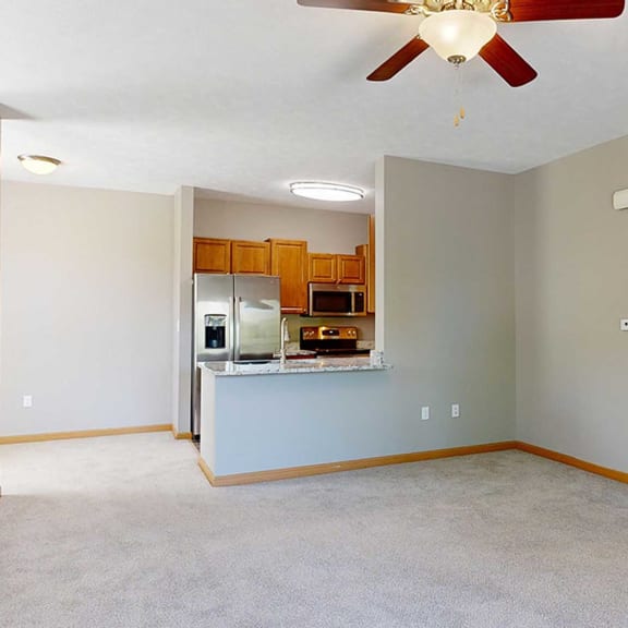 Thumbnail 4 of 24 a living room with a ceiling fan adjacent to a galley kitchen