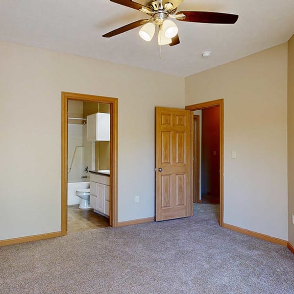 Thumbnail 18 of 32 a bedroom with a ceiling fan and attached bathroom