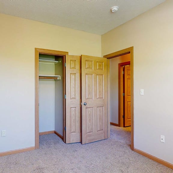Thumbnail 22 of 32 a bedroom with a closet and a door to a hallway