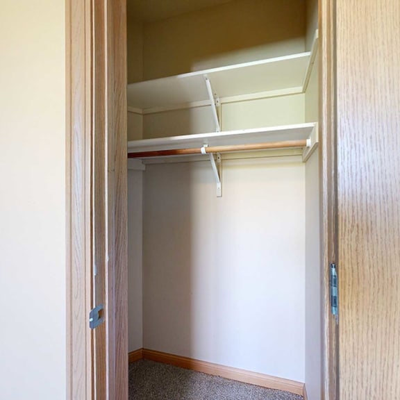 Thumbnail 24 of 32 a closet with a door and built in shelving